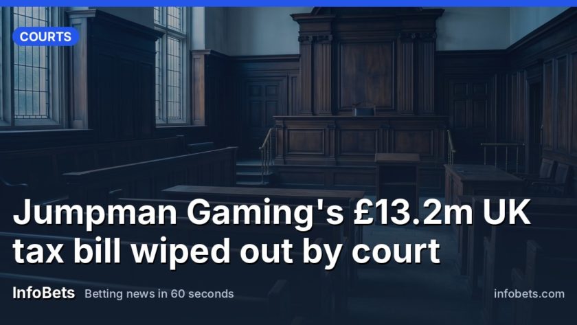 An empty courtroom with wood panelling & an unmarked judge's bench lit by soft daylight.
