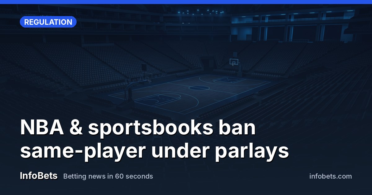 An empty basketball arena at dusk with the court lights dimmed & seats bare.