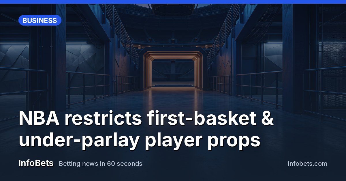 An empty basketball arena hallway at dusk with polished floors & a single tunnel entrance leading to the court.